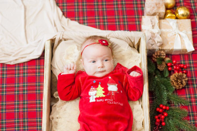 Beautiful little baby celebrates Christmas. New Year`s holidays. Baby in a Christmas costume. With gift royalty free stock images Beautiful little baby celebrates Christmas. New Year`s holidays. Baby in a Christmas costume. With gift royalty free stock images
