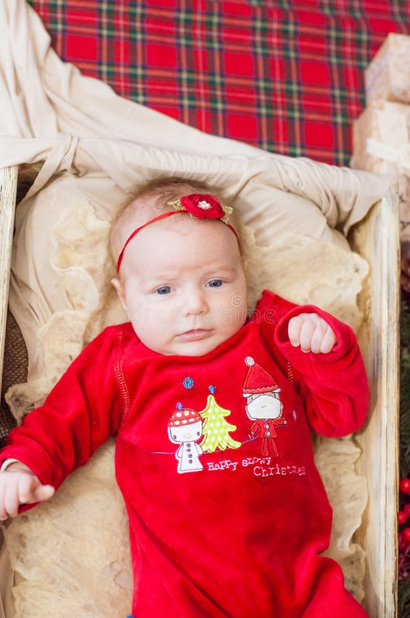 Beautiful little baby celebrates Christmas. New Year`s holidays. Baby in a Christmas costume. With gift royalty free stock photos Beautiful little baby celebrates Christmas. New Year`s holidays. Baby in a Christmas costume. With gift royalty free stock photos