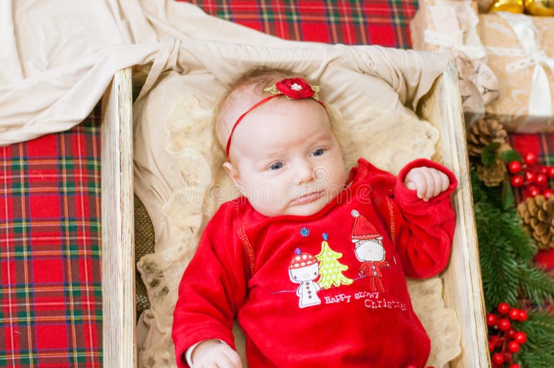Beautiful little baby celebrates Christmas. New Year`s holidays. Baby in a Christmas costume. With gift royalty free stock photos Beautiful little baby celebrates Christmas. New Year`s holidays. Baby in a Christmas costume. With gift royalty free stock photos