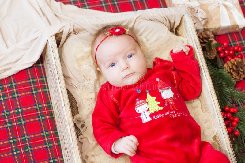 Beautiful little baby celebrates Christmas. New Year`s holidays. Baby in a Christmas costume. With gift stock images Beautiful little baby celebrates Christmas. New Year`s holidays. Baby in a Christmas costume. With gift stock images