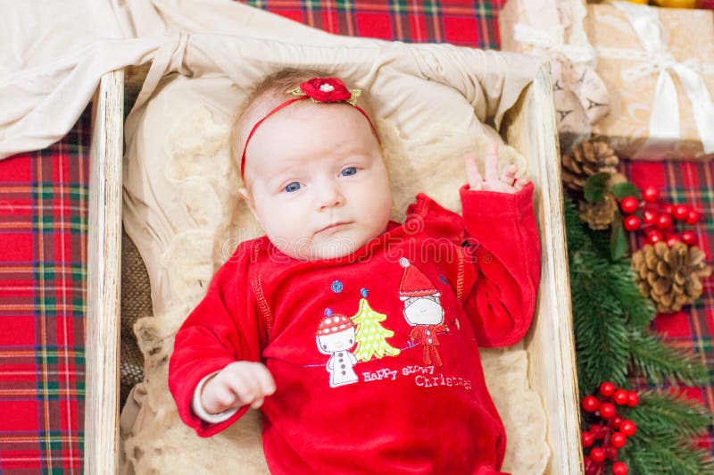 Beautiful little baby celebrates Christmas. New Year`s holidays. Baby in a Christmas costume. With gift royalty free stock image Beautiful little baby celebrates Christmas. New Year`s holidays. Baby in a Christmas costume. With gift royalty free stock image