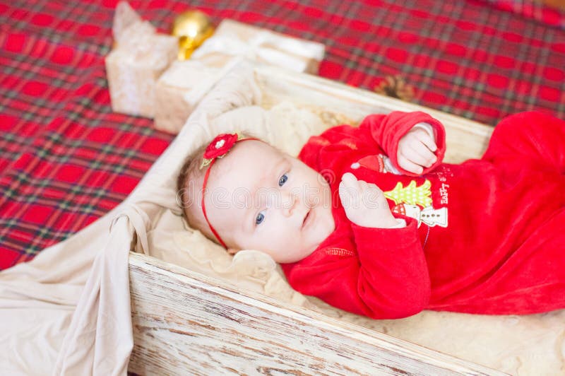 Beautiful little baby celebrates Christmas. New Year`s holidays. Baby in a Christmas costume. With gift royalty free stock photography Beautiful little baby celebrates Christmas. New Year`s holidays. Baby in a Christmas costume. With gift royalty free stock photography