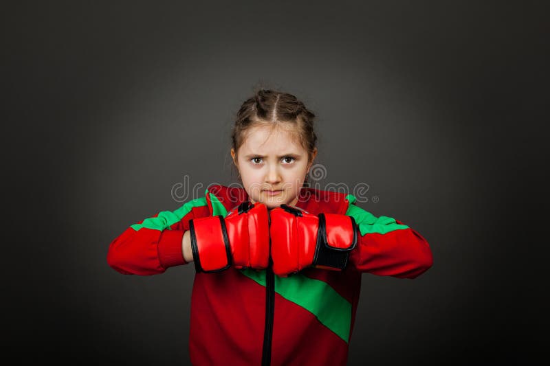 Beautiful little girl boxer in gloves ready to fight