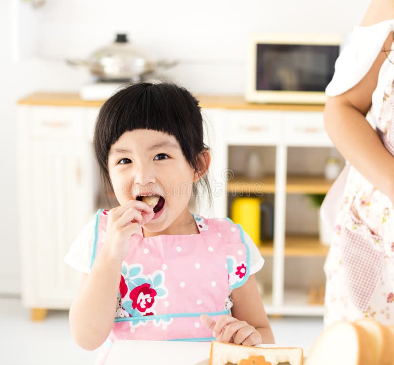 Beautiful little girl eating in the kitchen royalty free stock photos Beautiful little girl eating in the kitchen royalty free stock photos