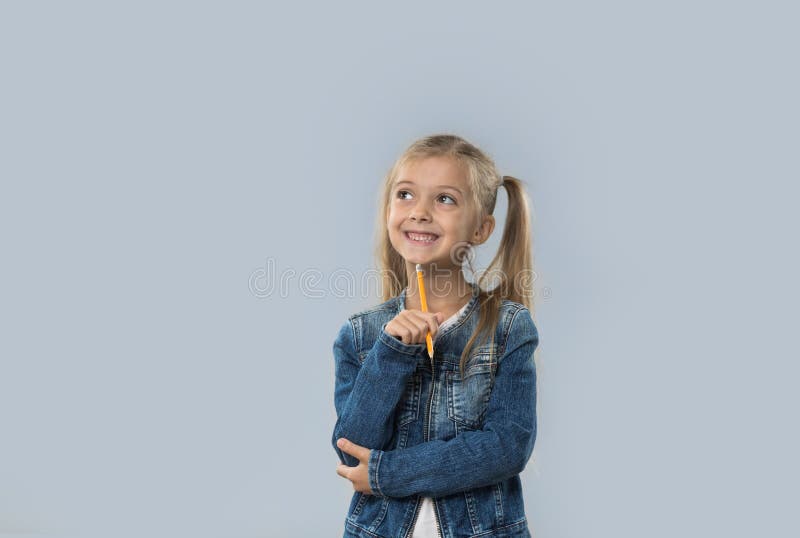 Beautiful Little Girl Hold Pencil Writing Thinking Happy Smiling Looking To Copy Space Isolated stock photo Beautiful Little Girl Hold Pencil Writing Thinking Happy Smiling Looking To Copy Space Isolated stock photo