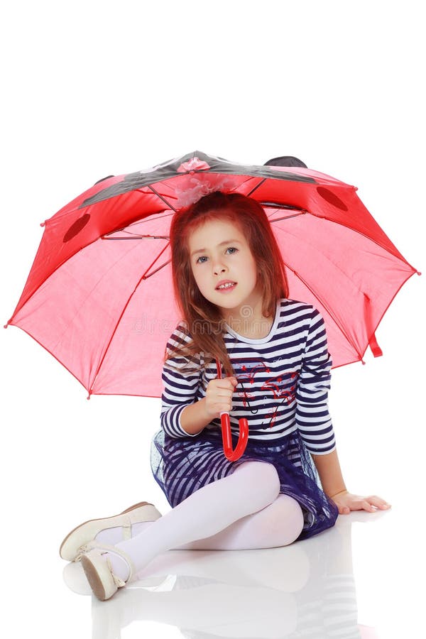 Little girl hiding under an umbrella.