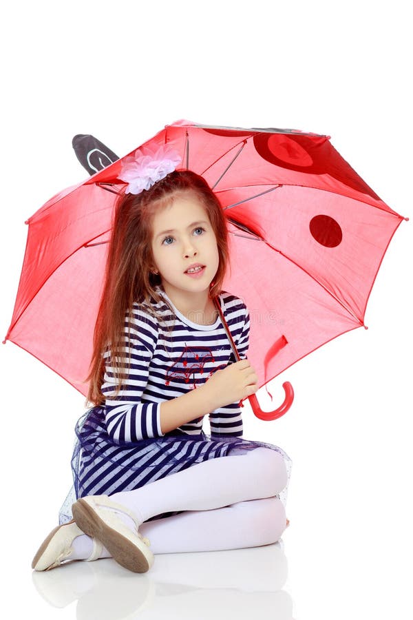 Little girl hiding under an umbrella.