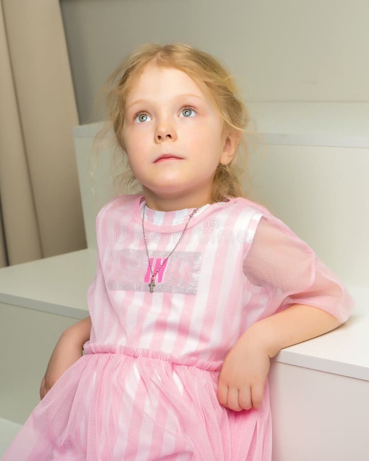 Beautiful little girl is sitting on the white staircase. royalty free stock images Beautiful little girl is sitting on the white staircase. royalty free stock images