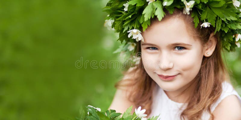 Beautiful little girl in a white dress in spring wood. Pretty little girl with a wreath from spring flowers on the head. Easter royalty free stock image Beautiful little girl in a white dress in spring wood. Pretty little girl with a wreath from spring flowers on the head. Easter royalty free stock image
