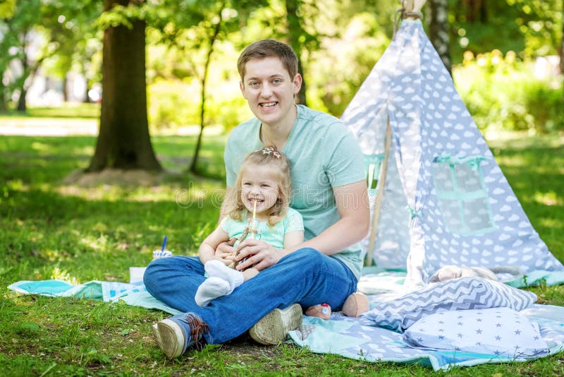 Beautiful little preschool girl playing with dad in the park.The stock photos Beautiful little preschool girl playing with dad in the park.The stock photos