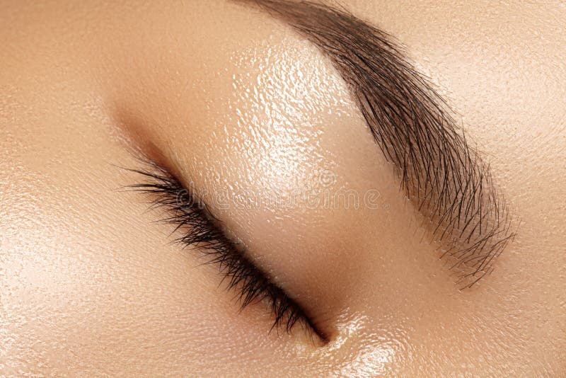 Beautiful macro of female eye with clean makeup. Perfect shape eyebrows. Cosmetics and make-up. Care about eyes