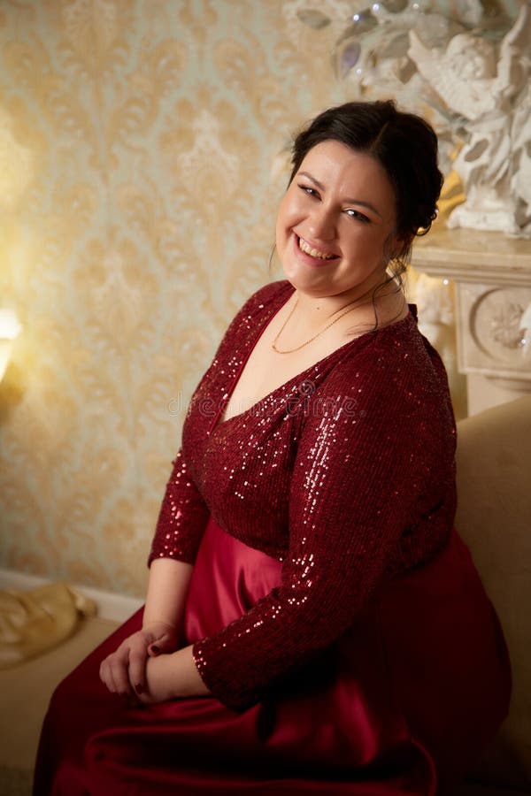 A Beautiful Majestic Solemn Fat Queen In A Red Elegant Dress In A