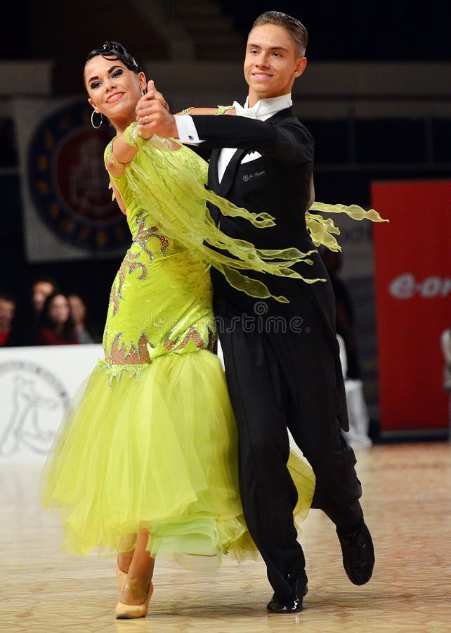 Beautiful man and woman perform smiling during dancesport competition