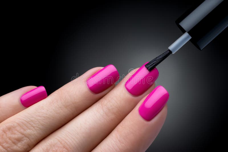 Beautiful manicure process. Nail polish being applied to hand, polish is a pink color. royalty free stock photography Beautiful manicure process. Nail polish being applied to hand, polish is a pink color. royalty free stock photography