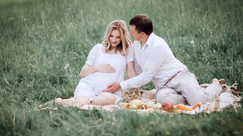 Beautiful married couple sitting on the grass during picnic royalty free stock photo Beautiful married couple sitting on the grass during picnic royalty free stock photo