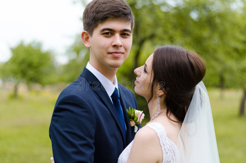A beautiful married couple in wedding dresses, posing for a photo shooting in an belarusian village. Green background stock photo A beautiful married couple in wedding dresses, posing for a photo shooting in an belarusian village. Green background stock photo