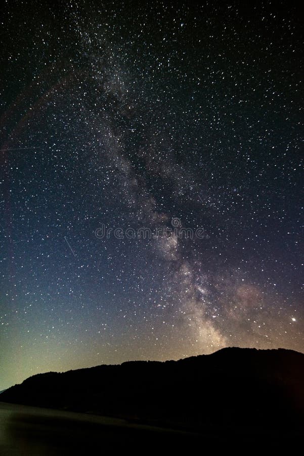 Beautiful Milky way and stars with silouhette trees and lake