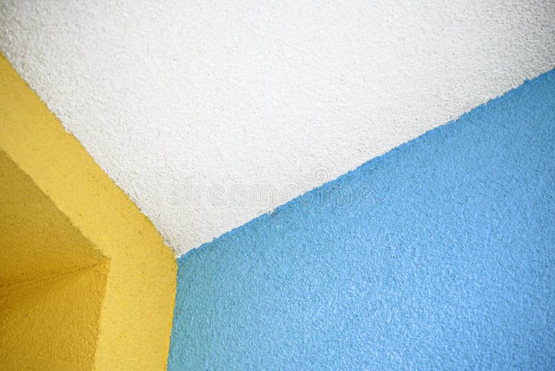 White ceiling edge with colorful blue and yellow walls, coated with roughcast royalty free stock photo