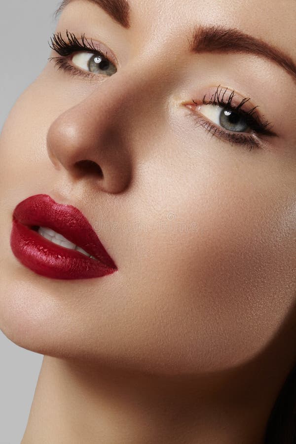 Beautiful model with fashion make-up. Close-up portrait woman with glamour lip gloss makeup and bright eye shadows.