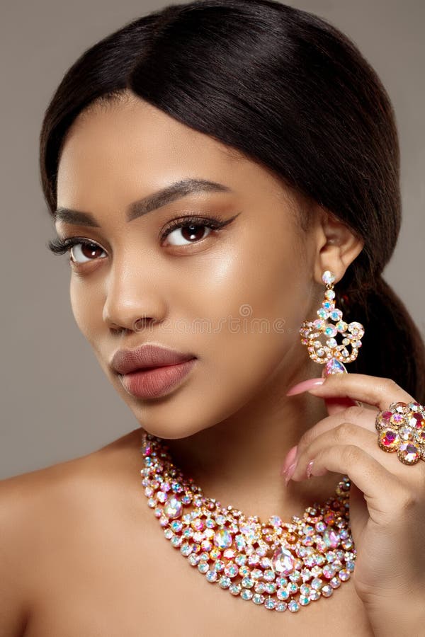 Beautiful model girl with set of Jewelry. Luxury girl in shine jewellry: Eearrings, Necklace, and Ring. Woman in jewelry from Gold