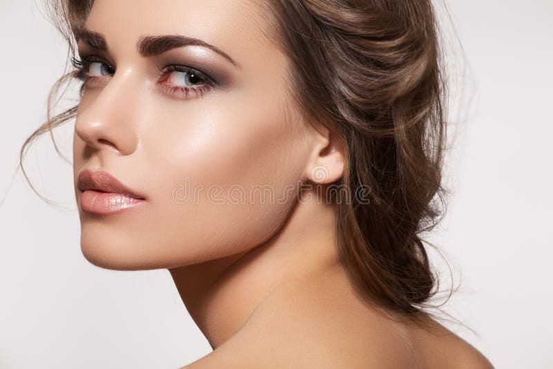 Krásná žena model s dokonalým kudrnatý účes a naturel svěží make-up, béžová lesk na rty a je ideální lesklé kůže.