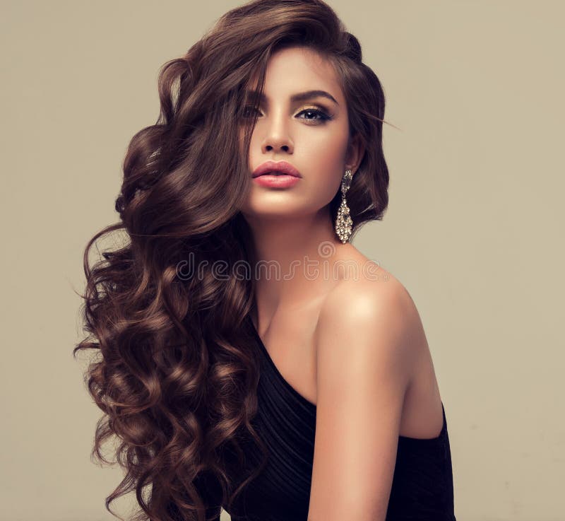 Beautiful model with long, dense and curly hairstyle.