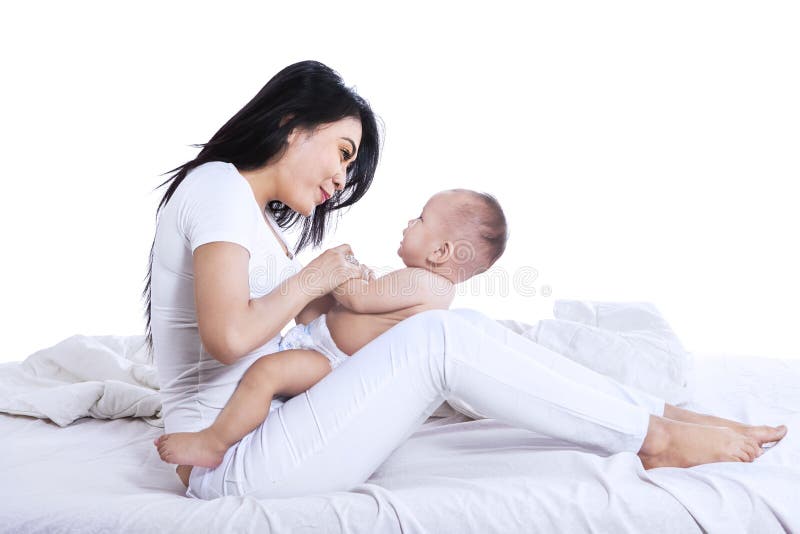 Beautiful mother and baby playing in the bedroom