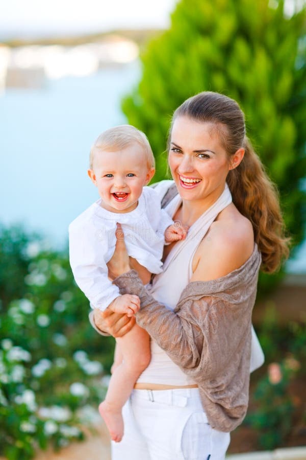 Beautiful mother with cute little baby on street