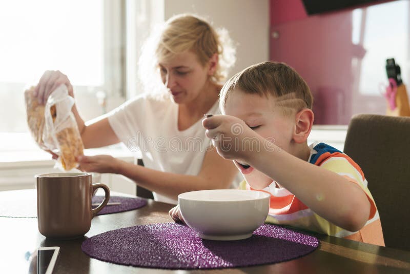Beautiful Mother And Her Cute Son Eating Healthy Cornflakes For