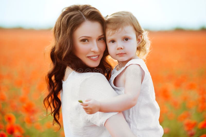 Mother and daughter playing in flower field stock photo Mother and daughter playing in flower field stock photo