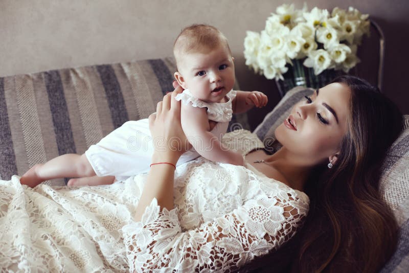 Beautiful mother with luxurious dark hair and her little baby
