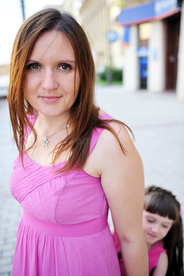 Beautiful mother in pink dress posing outdoors