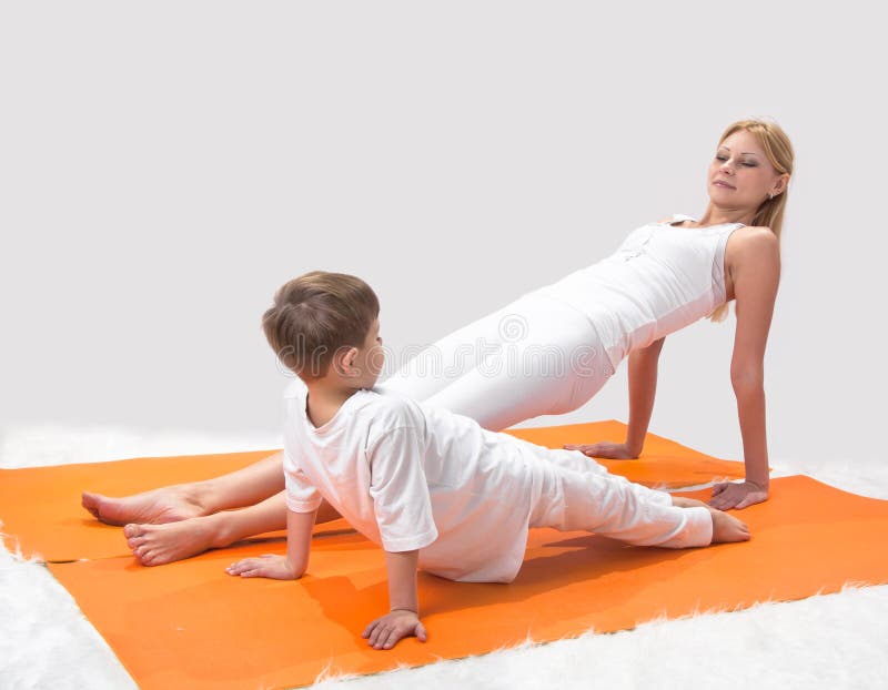 A beautiful mother practices yoga with her son.