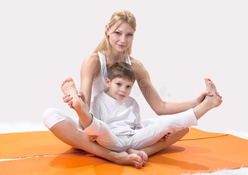 A beautiful mother practices yoga with her son.