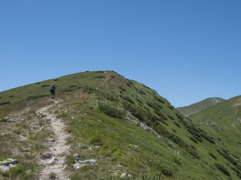 Krásná horská krajina Západních Tater nebo Roháčů s mužským turistou s batohem turistickou stezkou na hřebeni