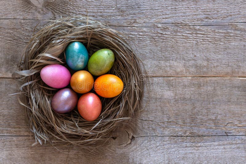 Beautiful multi-colored Easter eggs lie in a nest on a old wooden background, Easter holiday, copy space stock photography Beautiful multi-colored Easter eggs lie in a nest on a old wooden background, Easter holiday, copy space stock photography