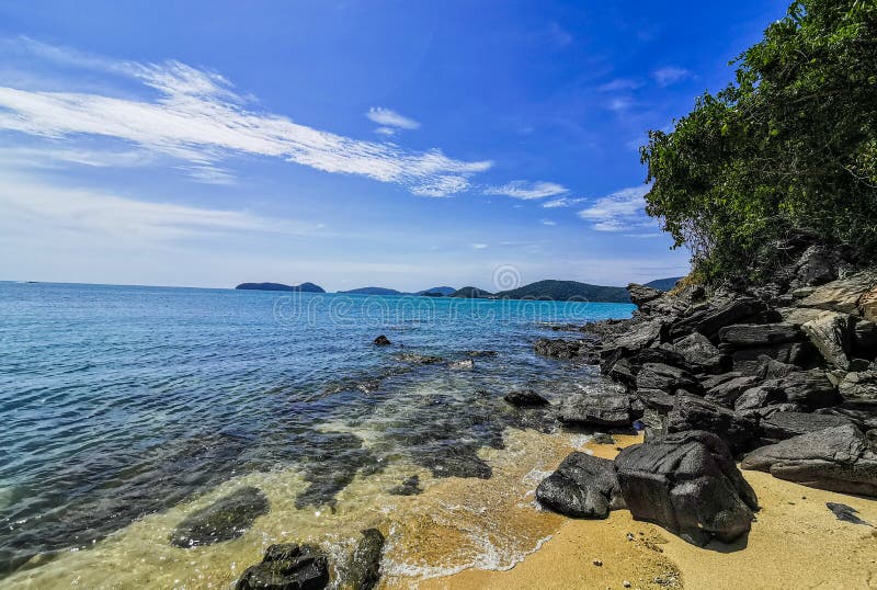 Beautiful nature background - Black stones are lined up by the blue sea. On a clear day at Panwa Cape, Phuket, Thailand. Another