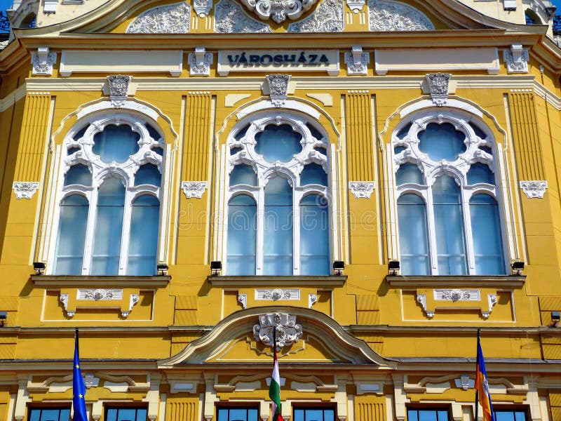 beautiful neo baroque style exterior elevation detail. the city hall in Pecs, Hungary. richly yellow stucco facade