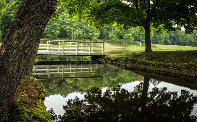 Hiking trail in crosses a wooden bridge over a small stream in the pastoral setting of Scioto Trail State Park in Chillicothe Ohio. Hiking trail in crosses a wooden bridge over a small stream in the pastoral setting of Scioto Trail State Park in Chillicothe Ohio.