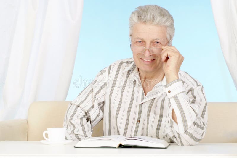 Beautiful old Caucasian man with book sits