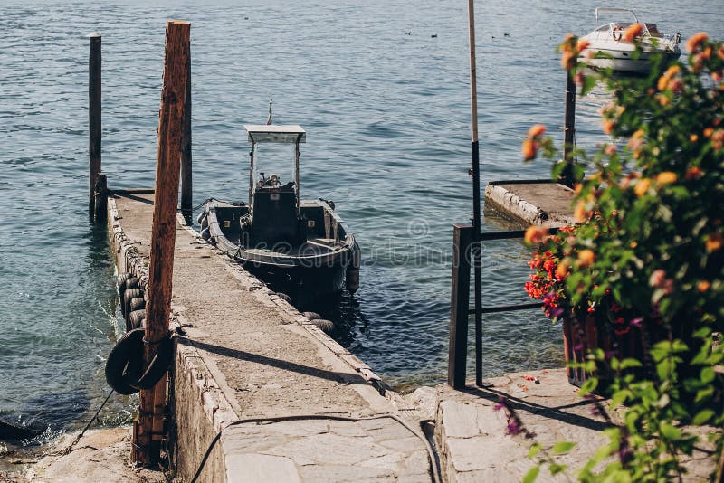 Beautiful old dock with aged wooden columns and boat on shore of Lago Maggiore on Borromean Islands near Stresa city, Italy. Pier royalty free stock photos Beautiful old dock with aged wooden columns and boat on shore of Lago Maggiore on Borromean Islands near Stresa city, Italy. Pier royalty free stock photos