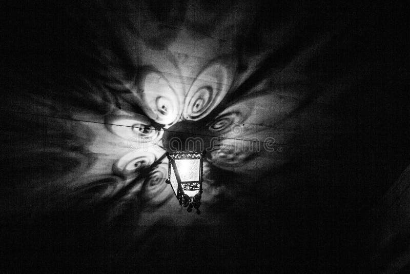 A beautiful old lantern gives beautiful shadows at night. Magical shadows. Black and white photo. royalty free stock images