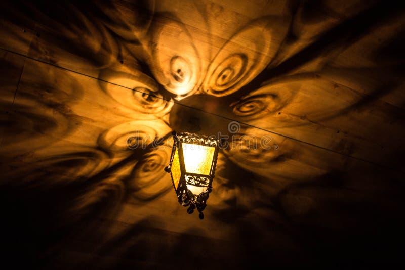 A beautiful old lantern gives beautiful shadows at night. Background. stock photography