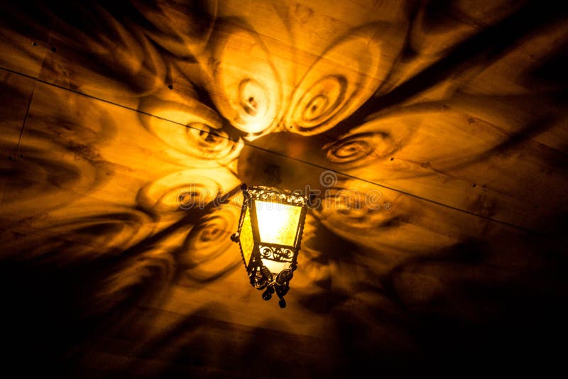 A beautiful old lantern gives beautiful shadows at night. Background. stock photo