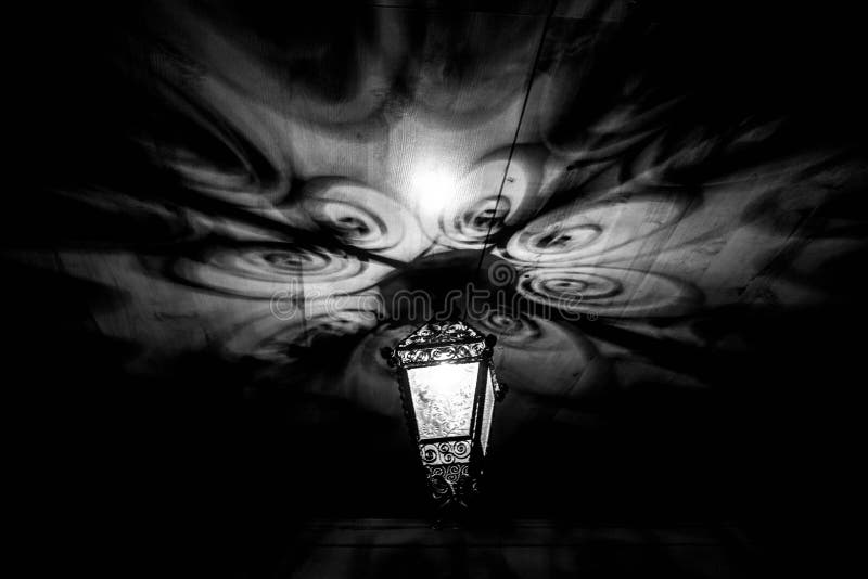 A beautiful old lantern gives beautiful shadows at night. Magical shadows. Black and white photo. stock photography