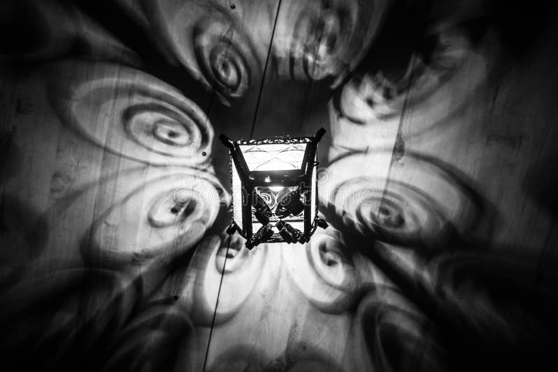 A beautiful old lantern gives beautiful shadows at night. Magical shadows. Black and white photo. stock photos