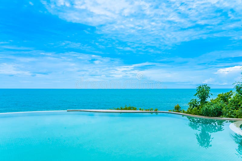 Beautiful outdoor infinity swimming pool in hotel resort with sea ocean view and white cloud blue sky