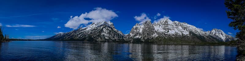 Beautiful panoramic view of grand Teton National Park, Wyoming, showing reflection of mountains on Jackson Lake near