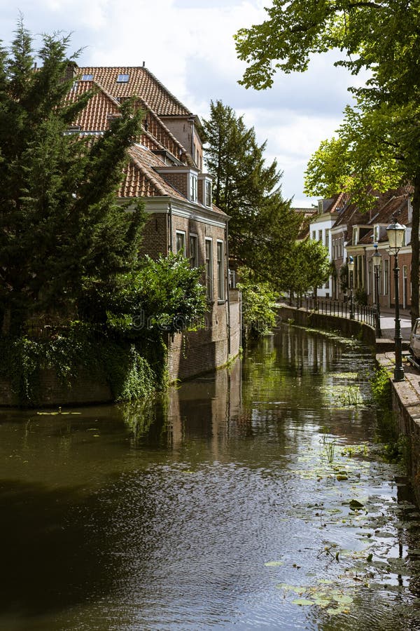 Beautiful and picturesque landscape of the village of Amersfoort. Typical dutch houses in front of a canal, riverside with trees royalty free stock image Beautiful and picturesque landscape of the village of Amersfoort. Typical dutch houses in front of a canal, riverside with trees royalty free stock image