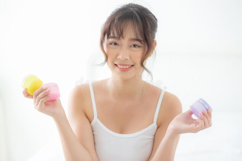 Beautiful portrait young asian woman attractive holding jars of cream and lotion skin for face fresh and soft at the room stock image Beautiful portrait young asian woman attractive holding jars of cream and lotion skin for face fresh and soft at the room stock image